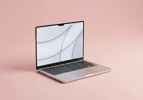 Aufgeklapptes MacBook Air vor rosa Hintergrund